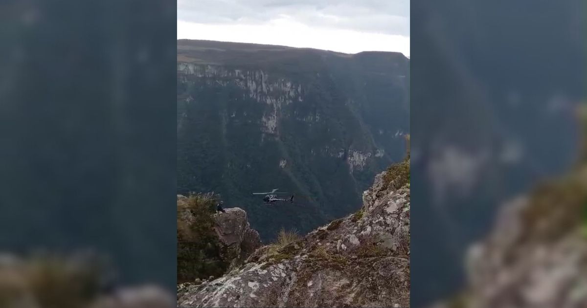 Imagem de um cânion com helicóptero, par afazer referência ao título: Menina de 12 anos cai e desaparece em cânion na divisa de SC