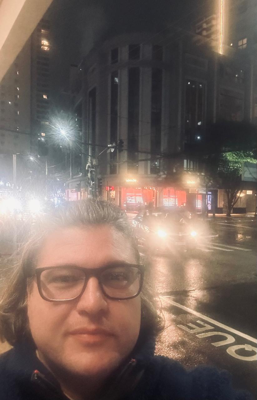 Selfie de Carlos Henrique em frente ao edifício.
