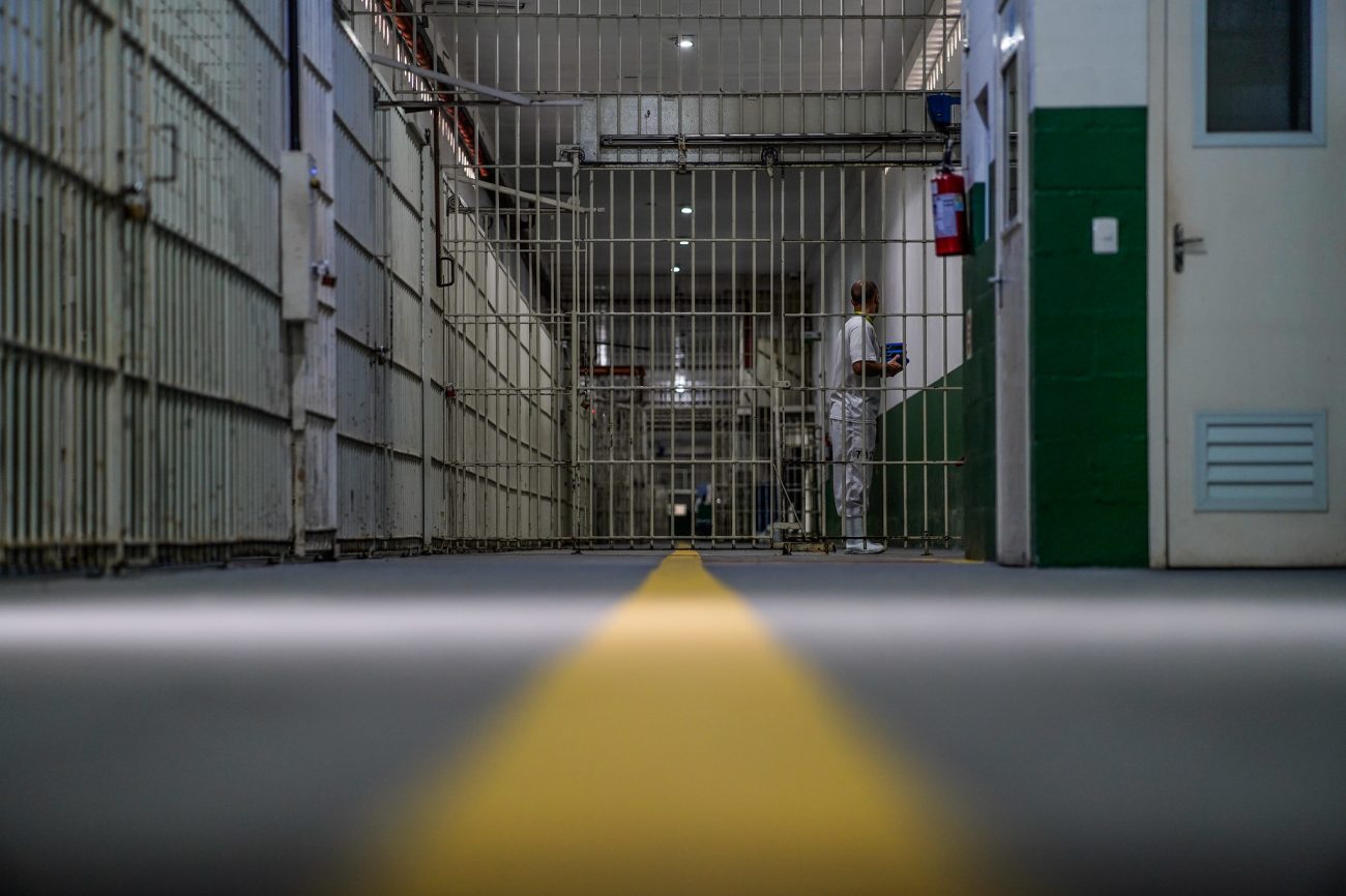 Imagem dos corredores de um presídio vazio, com postas abertas, para relacionar com o fato de que muitos presos precisaram ser transferidos de vários presídios, por conta da superlotação 