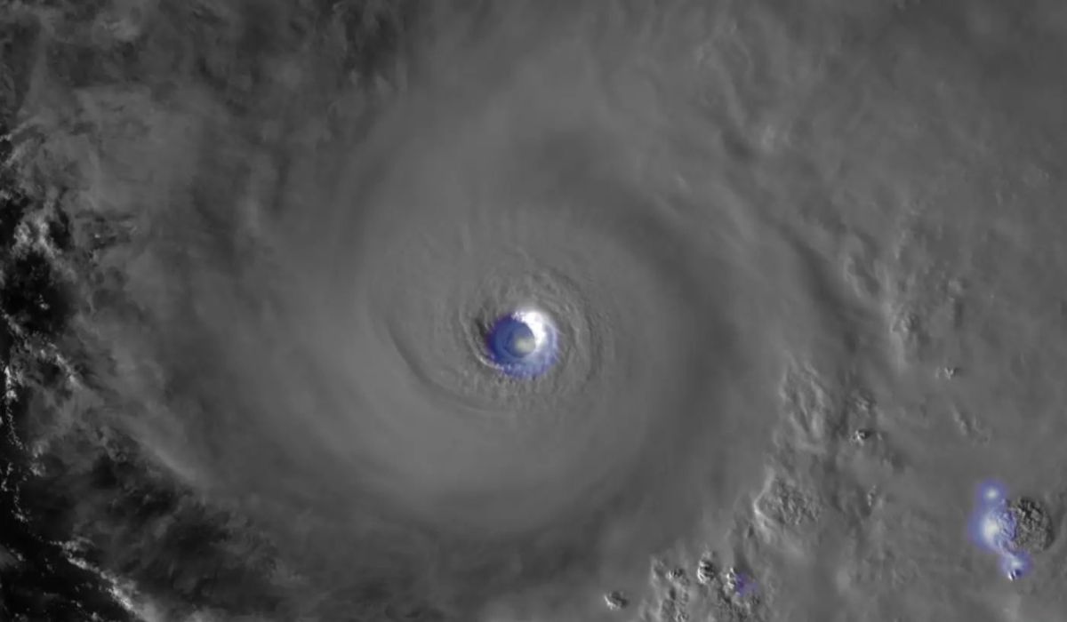 Imagem de um furacão visto de satélite com núcleo bem definido e núvens espessas ao redor, representando um fenômeno climático intenso.