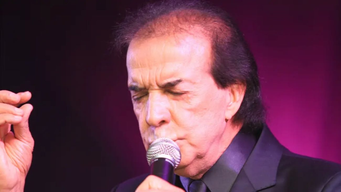 Cantor se apresentando no palco com microfone, em imagem associada a Nilton Cesar