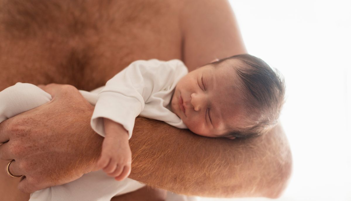 Pai segura bebê recém-nascido durante período de licença-paternidade
