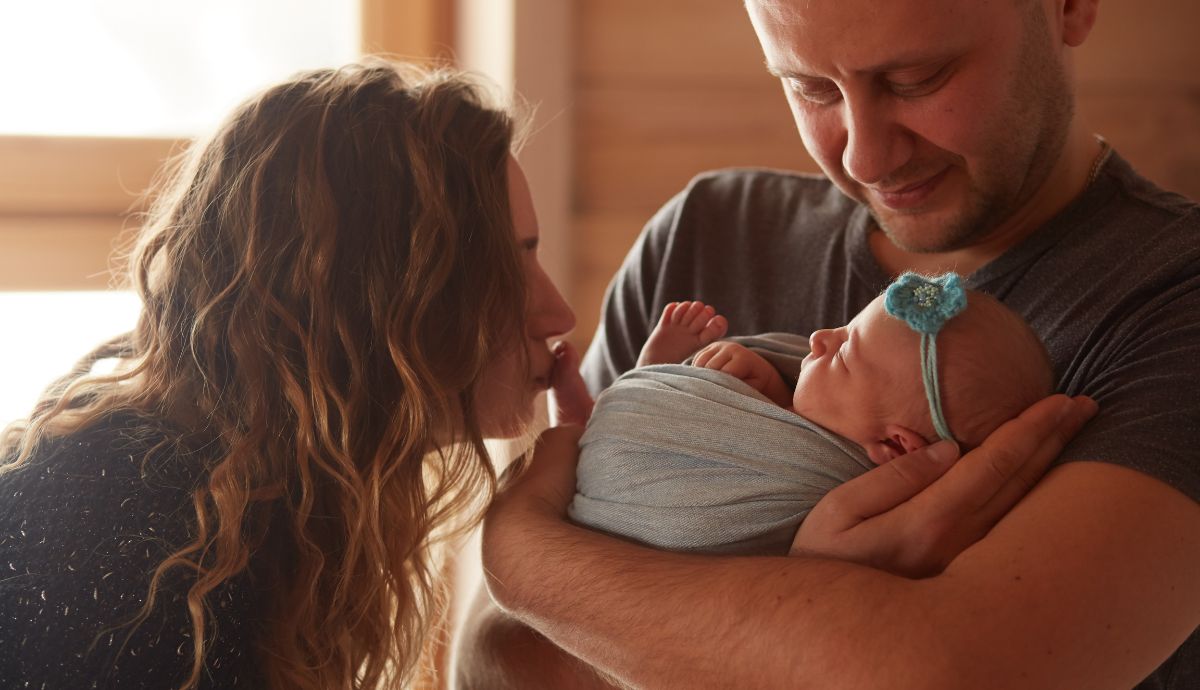 Casal com bebê recém-nascido em momento familiar ligado ao tema licença-paternidade