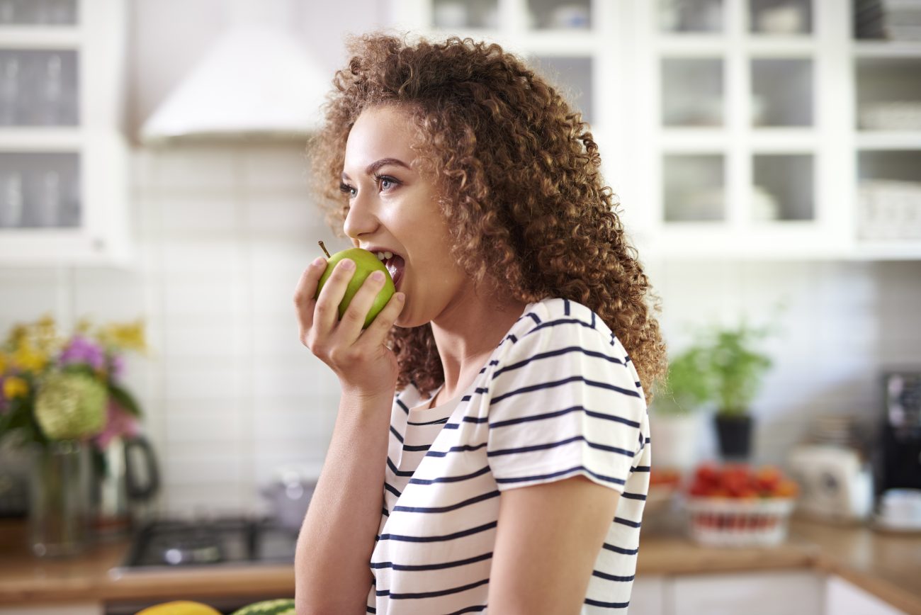 Mulher comendo uma fruta