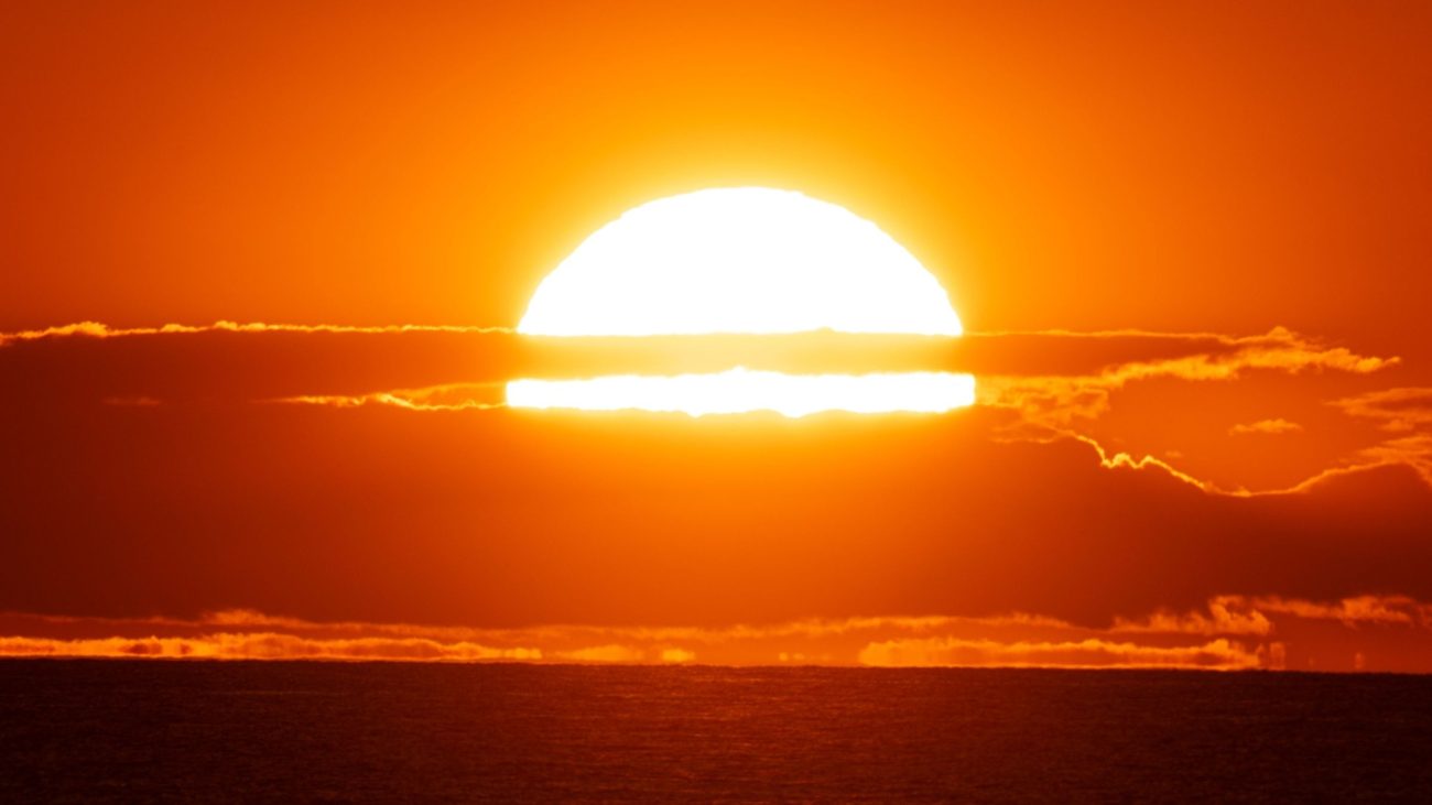 Sol intenso no horizonte durante o pôr do sol representa as altas temperaturas associadas aos impactos do El Niño sobre o clima.
