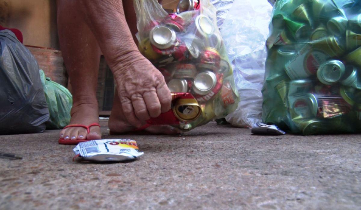 Homem recolhe latinhas para reciclagem; dinheiro obtido com a venda foi usado para comprar raspadinha premiada