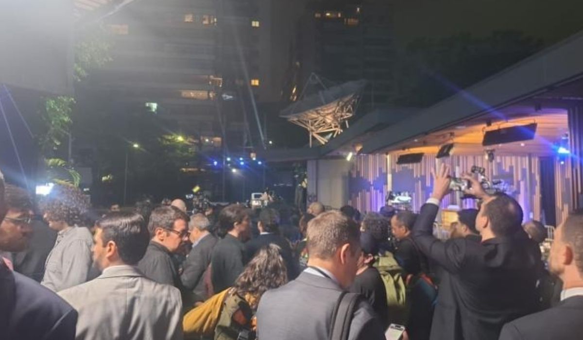 Convidados e integrantes de equipes reunidos na área externa da Band durante vistoria policial em carro da comitiva de Flávio Bolsonaro